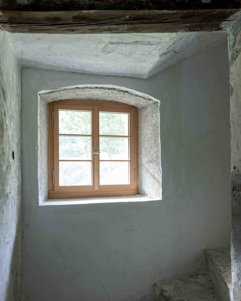 white stone walls, wooden window with double panes, wooden beams