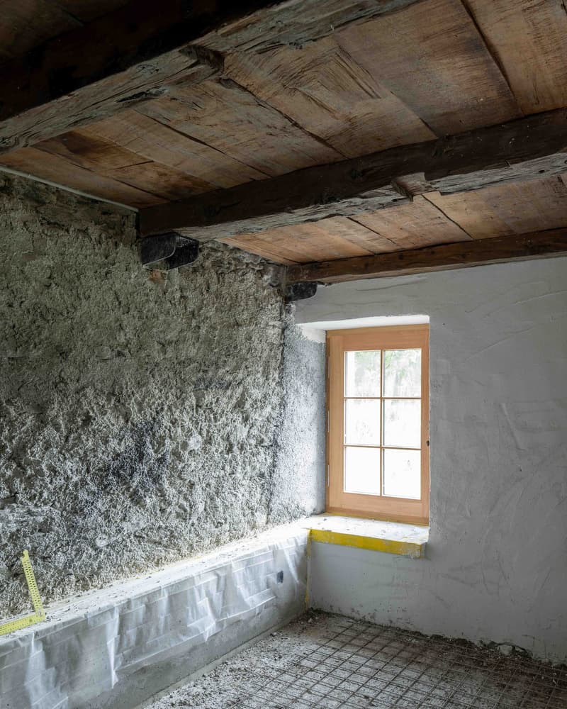 unfinished room, wooden ceiling, concrete wall, concrete floor, single window with sill