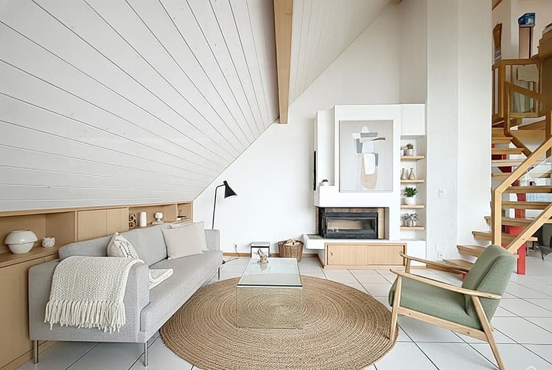 modern living room with fireplace, gray sofa, round coffee table, round rug, wooden chair, wooden shelves, wooden staircase