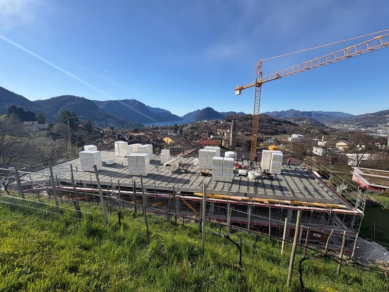 House under construction, rooftop, construction materials, crane, mountains in the background