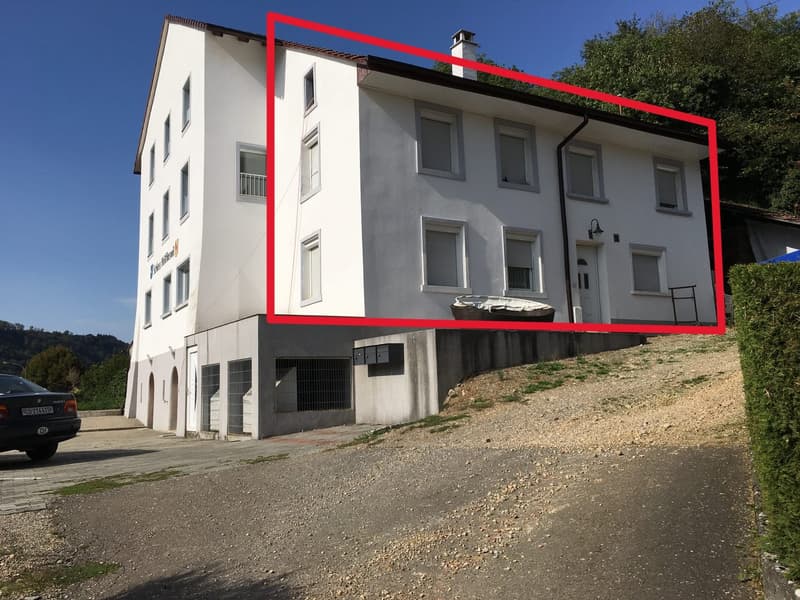 3-story white building with multiple windows, a chimney, and a gravel driveway in front.