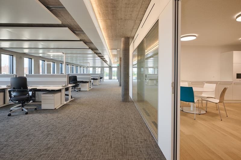 modern office space, carpeted floors, glass partition walls, modern furniture, cubicles