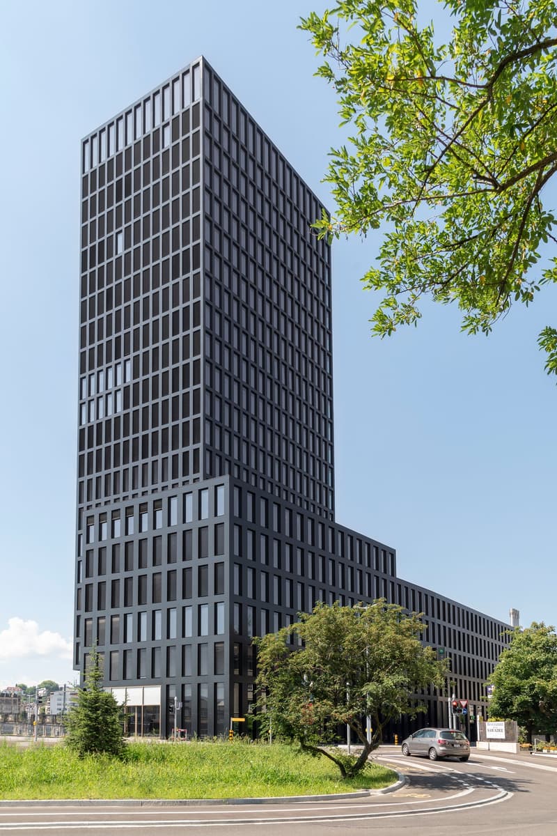 modern office building, tall with multiple floors, rectangular windows, black exterior
