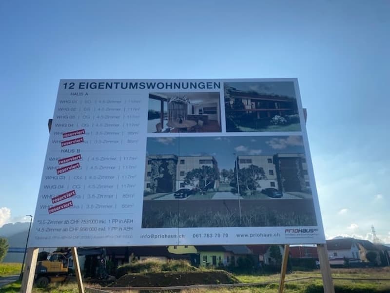 New residential complex billboard with house images and reservation information.