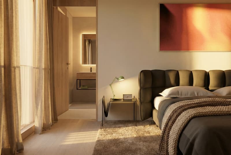 modern bedroom with beige walls, wooden flooring, bed with headboard, lamp, nightstand, rug, large window, bathroom with mirror and sink