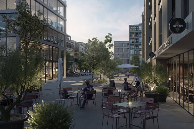 Outdoor seating area with tables and chairs, trees, and a building with glass windows.