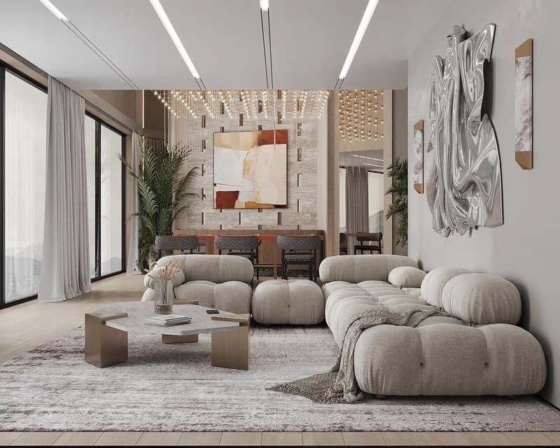 Spacious living room with large windows, modern lighting fixtures, plush seating area with multiple sofas and armchairs, abstract artwork on the wall, and a coffee table with decorative elements.