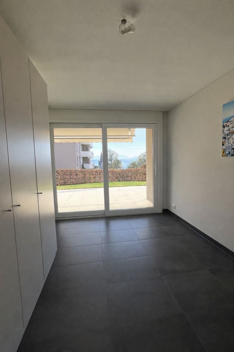empty room, sliding glass door, balcony, tiled floor, white walls, white cabinets