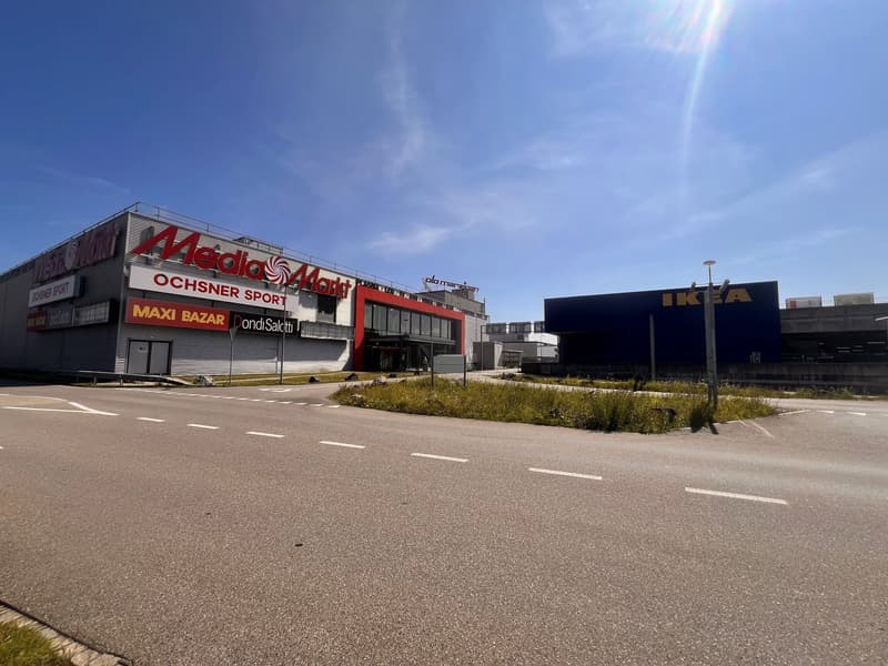 Buildings with signage, empty parking lot, street