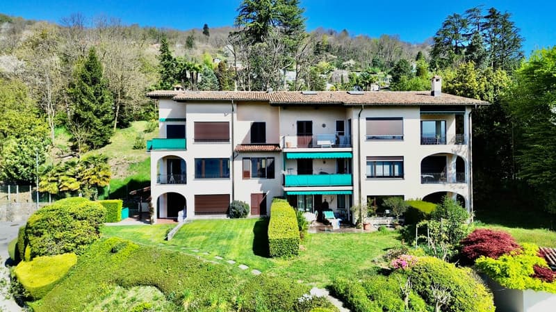 3 story house, white exterior, green balconies, large garden, trees, driveway