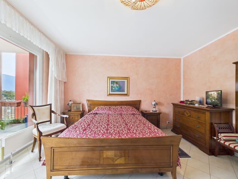 double bed, wooden furniture, pink walls, balcony, window, picture frame, lamp, TV