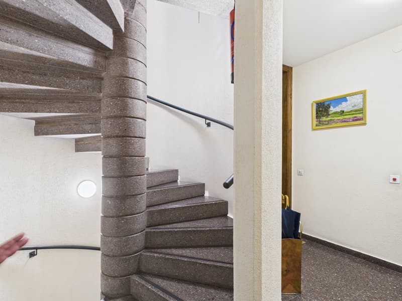 spiral staircase, concrete steps, metal handrail, white walls, picture frame, umbrella stand