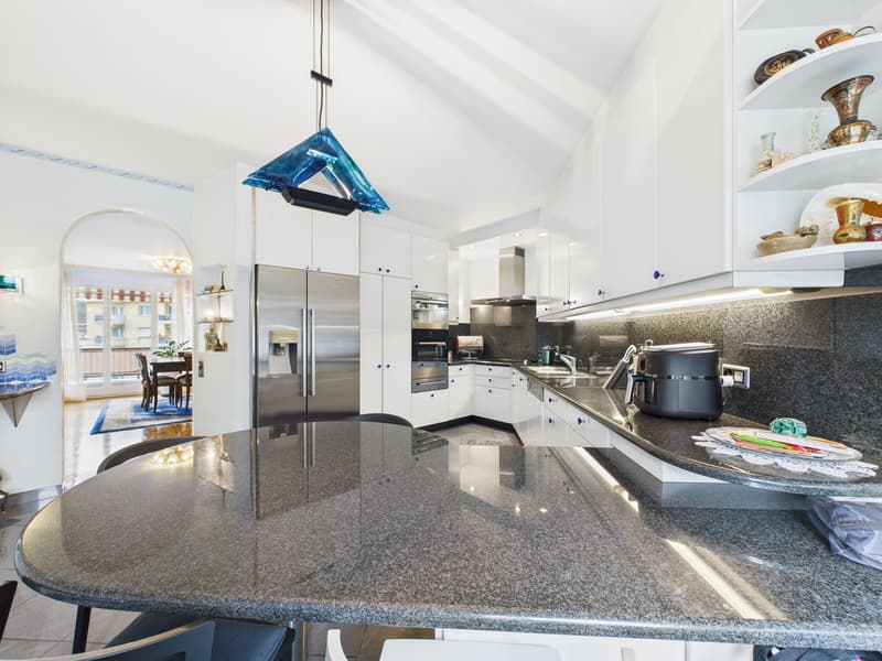 modern kitchen with granite countertops, stainless steel appliances, white cabinets, and a large island