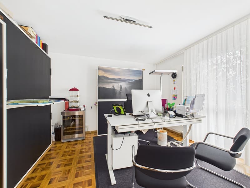 modern office setup with a desk, two chairs, a computer, a lamp, a wine cooler, and a large window with curtains