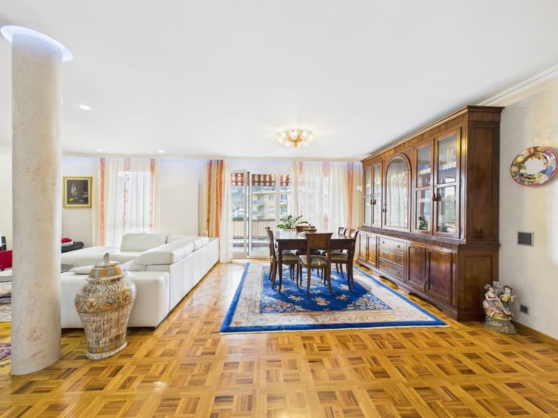 living room with wooden floor, white couch, dining table, wooden cabinet, rug, and a balcony