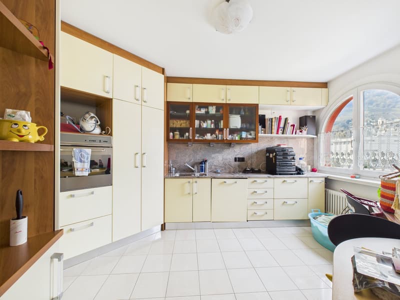 modern kitchen with white tiles, wooden cabinets, granite countertop, large window with view