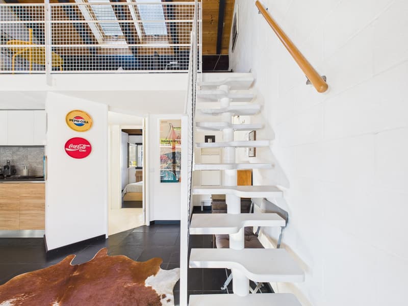 modern interior, white walls, black floor, white staircase, wooden handrail, open door, kitchen area, Pepsi and Coca-Cola signs