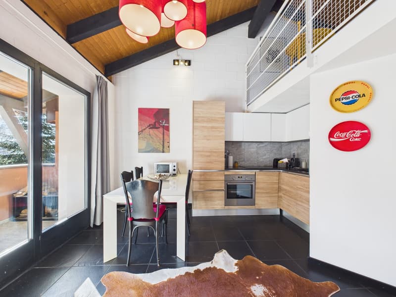 modern kitchen with dining area, wooden cabinets, white countertops, black tiled floor, large windows, balcony