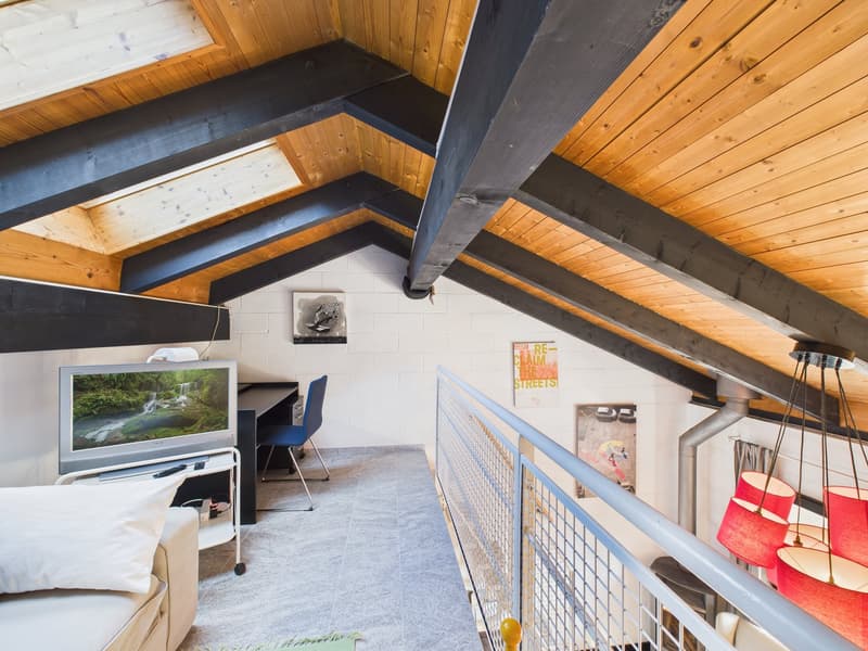 attic room with wooden ceiling, white walls, gray floor, desk, chair, TV, couch, lamps