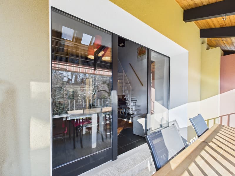 dining area with large glass doors, wooden table, chairs, staircase, balcony