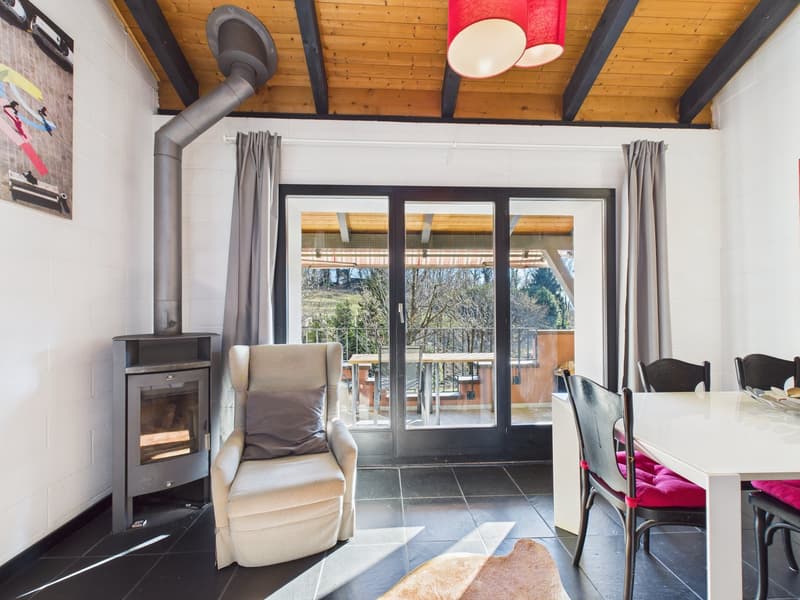 living room with fireplace, armchair, dining table, chairs, sliding glass doors, balcony