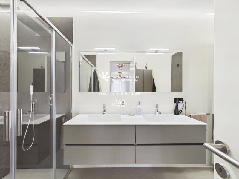modern bathroom, double sink, large mirror, glass shower enclosure, white tiles, towel rack, power outlet