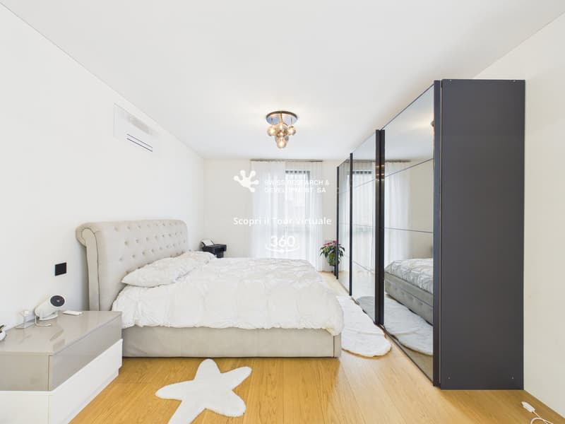 modern bedroom with white walls, wooden floor, large bed, white star rug, large mirror, white nightstand, ceiling lamp