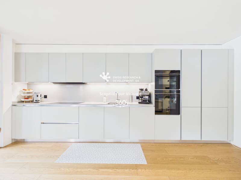 modern kitchen with white cabinets, wooden floor, double oven, dishwasher, sink, countertop, coffee machine, fruit basket