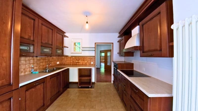 modern kitchen, wooden cabinets, white countertops, stainless steel appliances, tiled floor