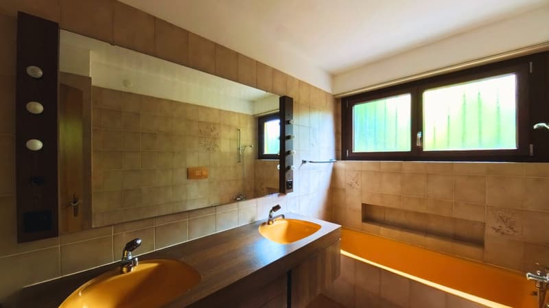 Double sink, bathtub, mirror, tiled walls, window