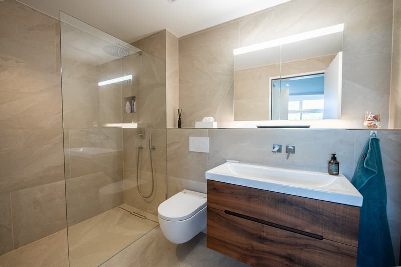 Badezimmer mit Regendusche und Dusch-WC