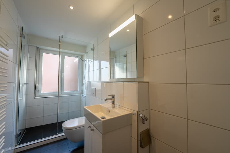 Badezimmer mit Dusche und Vorbereitung für einen Waschturm
