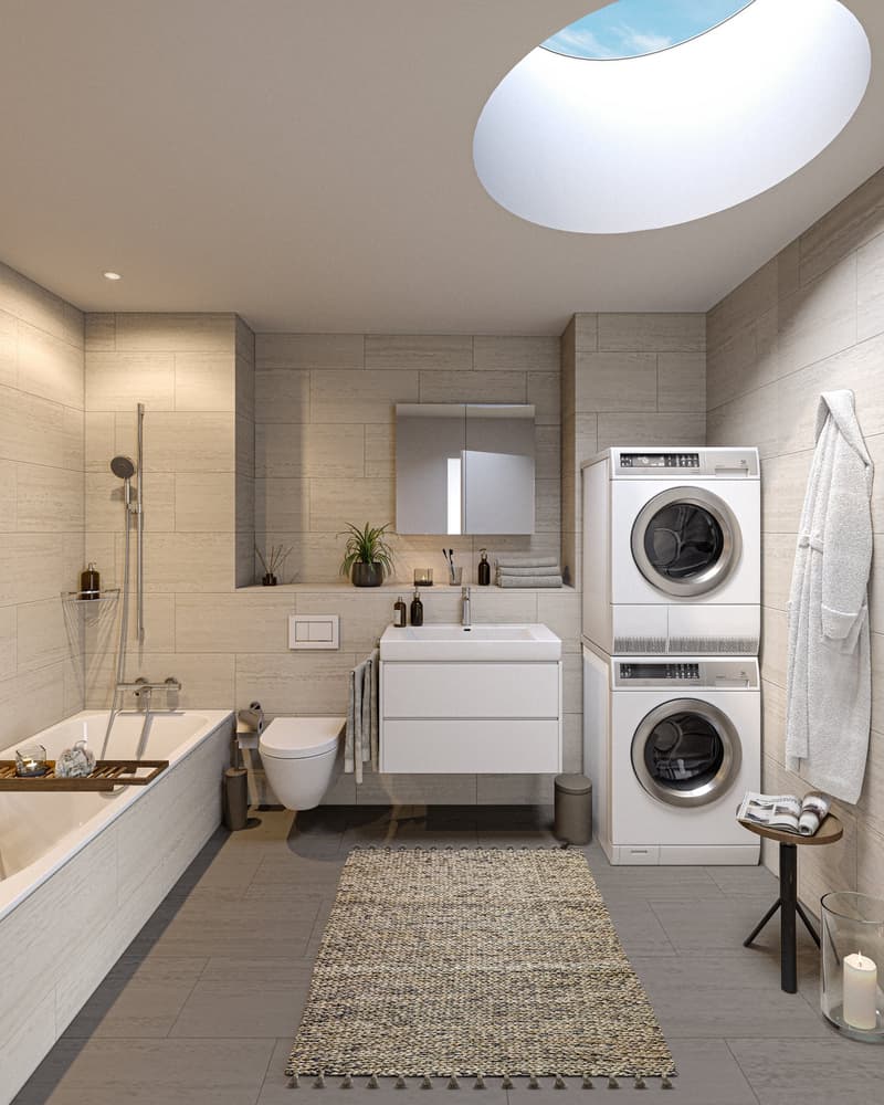 Spacious bathroom with modern design, featuring a vanity sink, toilet, bathtub, and a stacked washer and dryer unit. The room has a skylight and is decorated with neutral-toned tiles and accents.