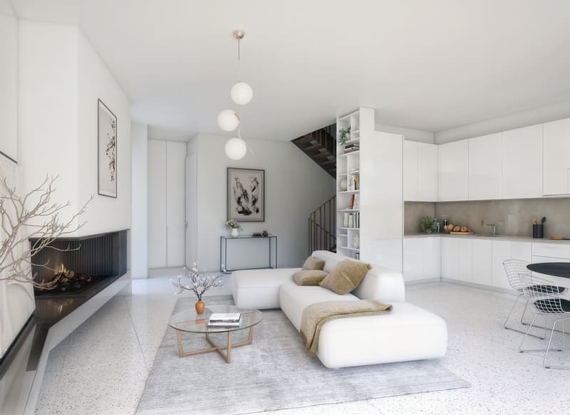Modern living room with white sofa, glass coffee table, fireplace, and pendant lights. White walls and floors. Kitchen area with white cabinets and island.