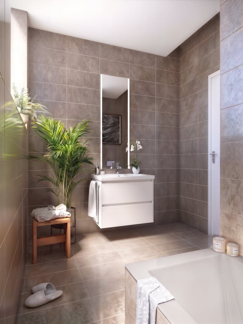 Modern bathroom with tiled walls, a white vanity, a large mirror, a bathtub, and a potted plant.