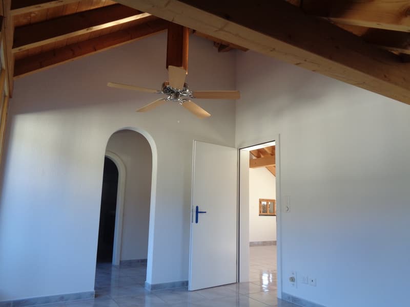 Empty room, white walls, ceiling fan, white tile floor, arched doorway, white door, light fixture
