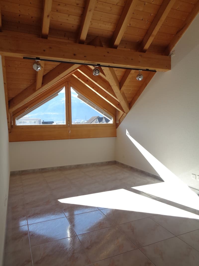 wooden attic ceiling, floor made of tiles, large triangular window, white walls