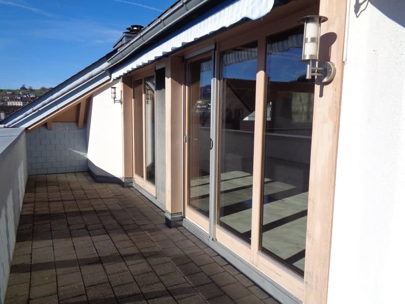 Balcony with wooden deck, glass doors, awning