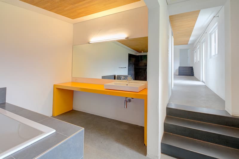 modern design, bright and clean, rectangular bathtub, yellow counter, white sink, tiled walls and floor
