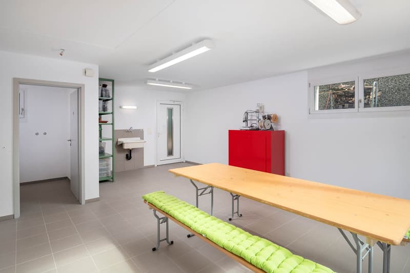 tiled floor, white walls, two doors, sink, wooden table, bench, long fluorescent lamps