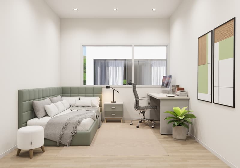 Spacious bedroom with large windows, green upholstered bed, desk with computer, and artwork on the walls