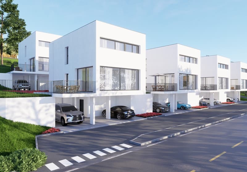 A modern, multi-unit residential complex with several white, cube-shaped buildings. The buildings have large windows and balconies, and there is a paved parking area in front with designated parking spaces.
