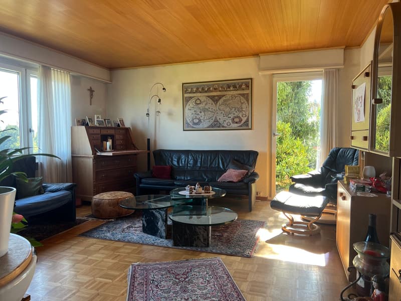 Wohnzimmer mit Panorama-Fenster mit Aussicht und Ausgang auf Gartensitzplatz