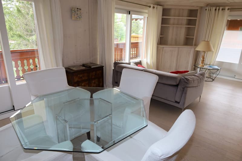 glass table, 4 white armchairs, couch, cabinet, balcony, floor windows