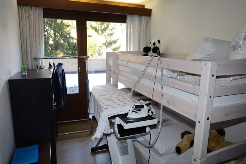 room with bunk beds, ironing board, lamp, cabinet, clothes hanger, window, balcony