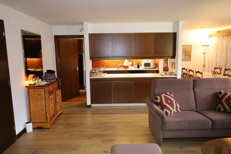 living room with couch, microwave, dining table, and kitchen