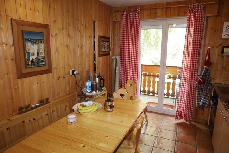 dining area with table, chairs, and balcony view, wooden walls and flooring, modern kitchen