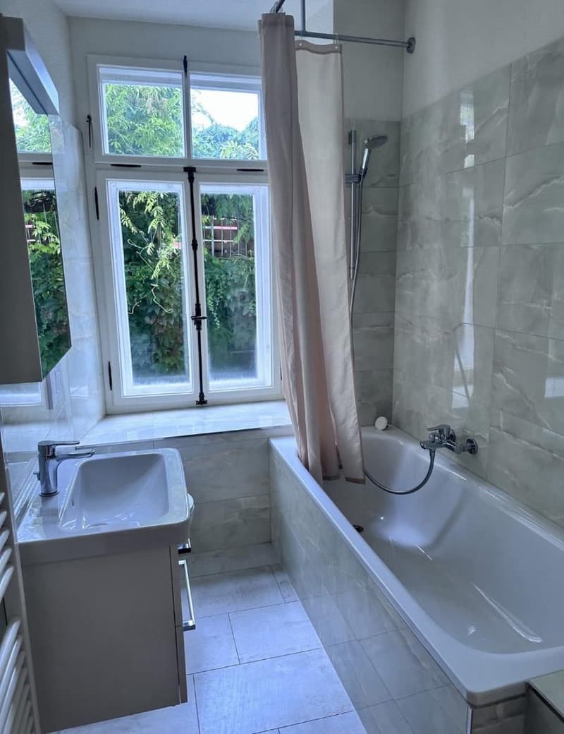 bathroom with bathtub, sink, shower, window with curtains, and radiator