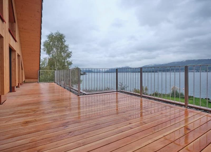modern wooden floor terrace, metal railings, lake view, mountain background