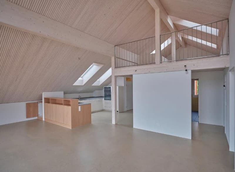 large room, wooden ceiling, metal railings, kitchen with wooden cabinets, wooden floors, white walls, loft area